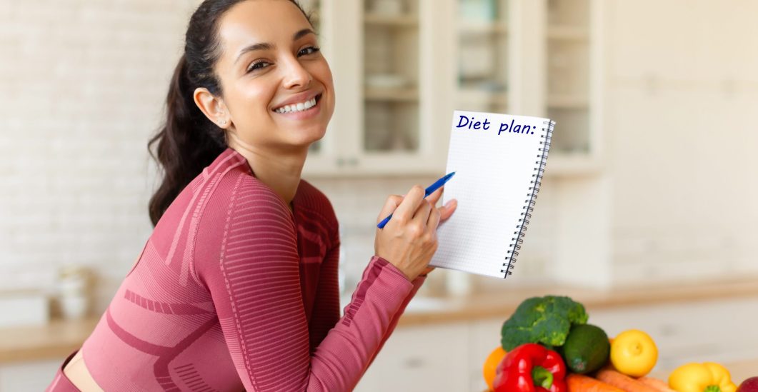 smiling-fit-woman-posing-with-diet-plan-in-modern-2023-11-27-04-49-46-utc