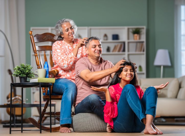 Indian couple and daughter family giving head massage